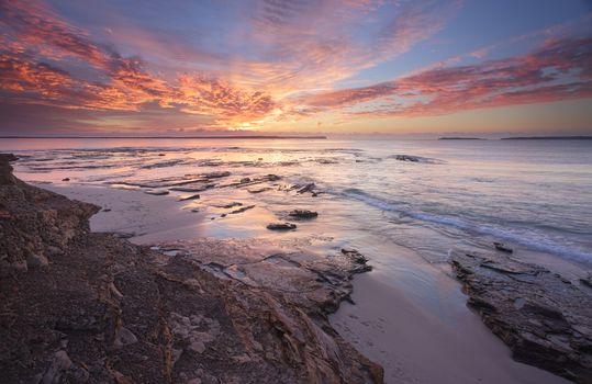 Spectacular sunrise over Jervis Bay from the rocks at Plantation Point