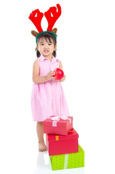 lovely asian girl holding an apple and enjoying christmas gift box