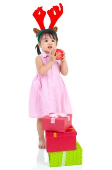 lovely asian girl holding an apple and enjoying christmas gift box
