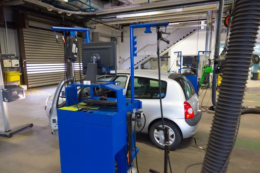 Car waiting for lights inspection and pollution measurements ontechnical review in car repair shop.