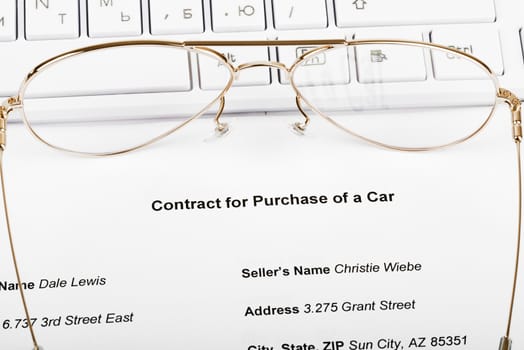 Keyboard with eyeglasses and document of purchase of car
