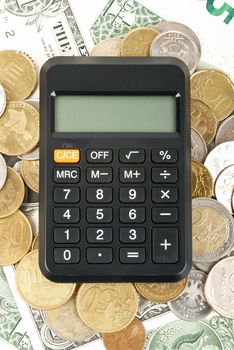 Calculator on gold coins background, close up view