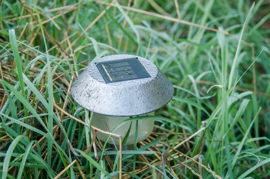 the garden lamp on solar batteries in a green garden among plants