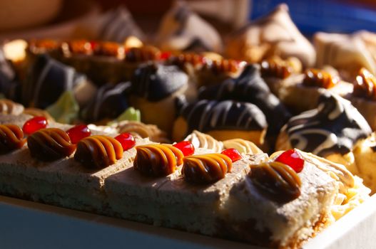 Many little pieces of cake and various tarts in a box