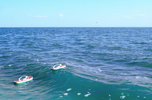 Pair of white flip-flops floating in the ocean