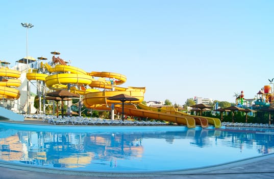 Various water slides over swimming pool in aqua centre outdoors