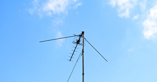 External outdoor TV antenna with amplifier in the blue sky