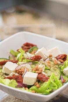 Salad feta cheese lettuce sausage cucumbers and pine nuts
