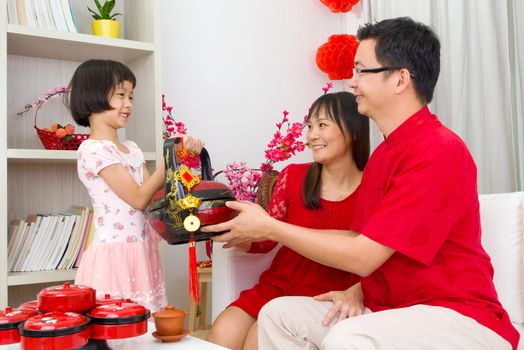 Asian girl presenting gift basket to parents on chinese new year