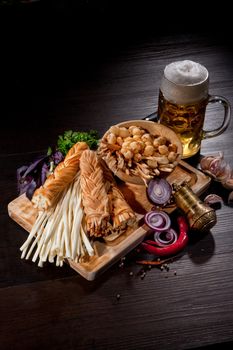 Cheese, glass of bier and vegetables on a wooden table