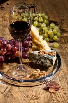 Winem cheese and grapes on a wooden table