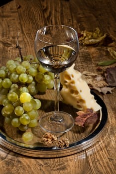 Winem cheese and grapes on a wooden table