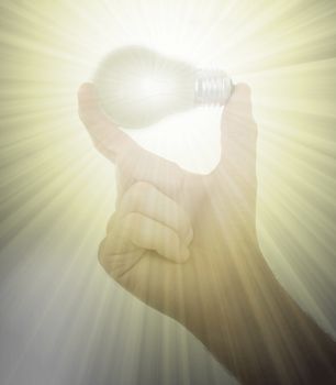 Hand holding an light bulb isolated on white background