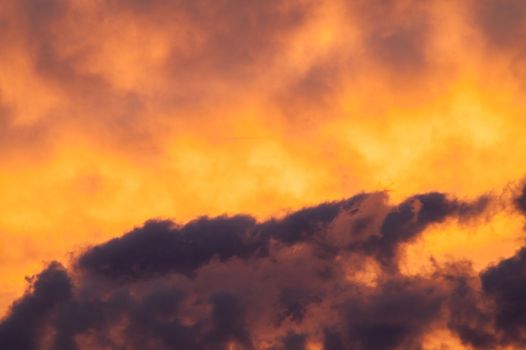 Beautiful fiery clouds at a sunset in the summer afternoon