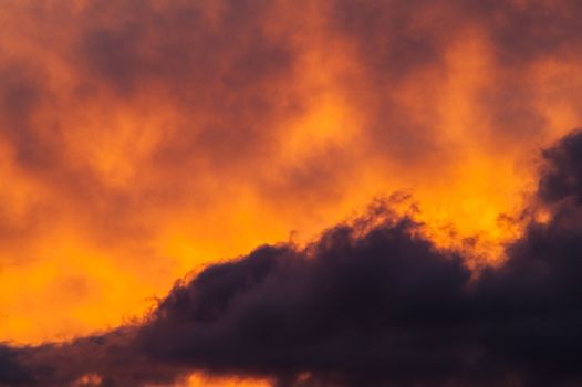 Beautiful fiery clouds at a sunset in the summer afternoon