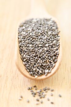 Chia seeds in wooden spoon on wooden table