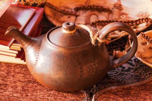 ancient clay teapot is handmade and a stack of books