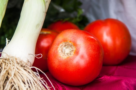 few red tomato close-up with green onions