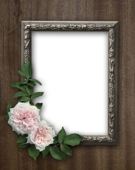 Vintage rose and blank photo frame on old wooden background