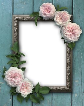 Vintage rose and blank photo frame on old wooden background