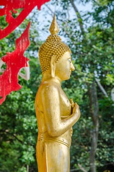 Old golden standing buddha in public in Thai Temple; Buddha of Friday