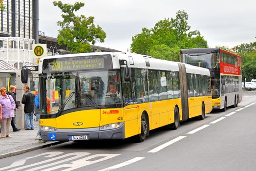 BERLIN, GERMANY - SEPTEMBER 10, 2013: Yellow Solaris Urbino 18 articulated city bus of the Berliner Verkehrsbetriebe bus company at the city street.