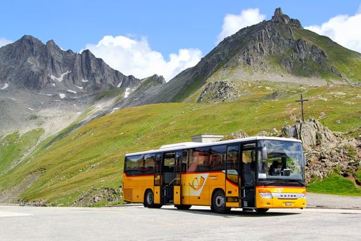 GOTTHARD PASS, SWITZERLAND - AUGUST 5, 2014: Yellow Setra S415H interurban coach at the high Alpine mountain road.