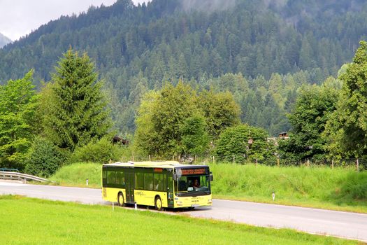 TYROL, AUSTRIA - JULY 29, 2014: Yellow suburban bus MAN A20 Lion's City UE at the high Alpine road.