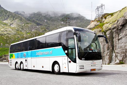 GOTTHARD PASS, SWITZERLAND - AUGUST 5, 2014: White touristic coach MAN R08 Lion's Top Coach at the high Alpine mountain road.