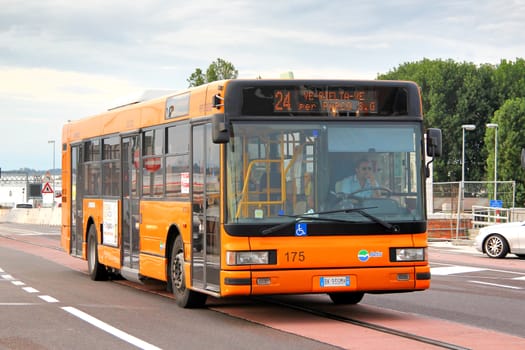 VENICE, ITALY - JULY 30, 2014: Orange city bus Iveco CityClass at the city street.