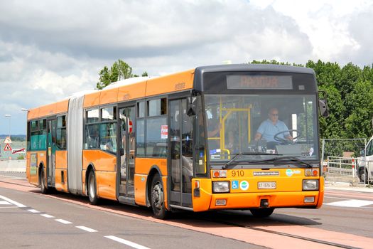 VENICE, ITALY - JULY 30, 2014: Orange articulated city bus Breda Menarini at the city street.
