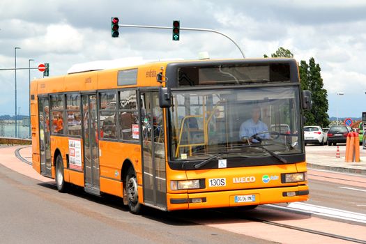 VENICE, ITALY - JULY 30, 2014: Orange city bus Iveco CityClass at the city street.