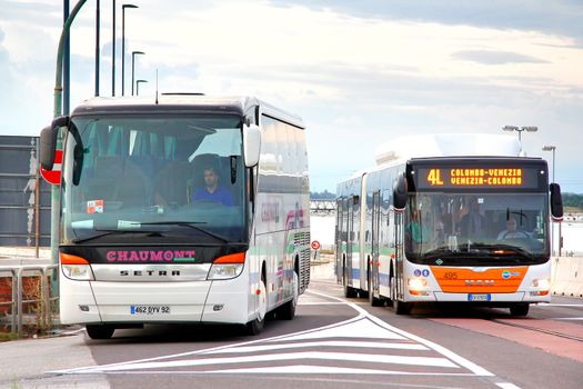 VENICE, ITALY - JULY 30, 2014: Interurban coach Setra S415HD and articulated city bus MAN A23 Lion's City G at the city street.