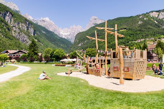Molveno, Italy - July 10: Playground structures with natural wood on the banks of Lake Molveno surrounded by the Alps in Molveno, Italy on July 10, 2015.