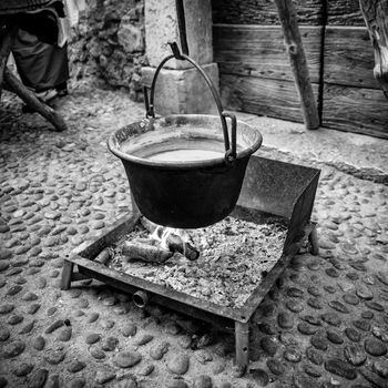 Copper pot hanging over the fire to heat water to make polenta.