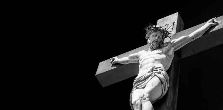 Crucifix made of marble with blue sky in background. France, Provence Region.