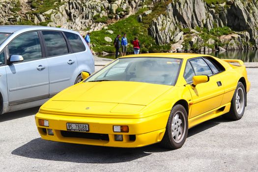 GOTTHARD PASS, SWITZERLAND - AUGUST 5, 2014: Yellow supercar Lotus Esprit at the high mountain Alpine road.