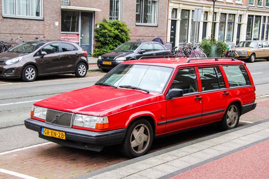 AMSTERDAM, NETHERLANDS - AUGUST 10, 2014: Red retro estate car Volvo 940 at the city street.