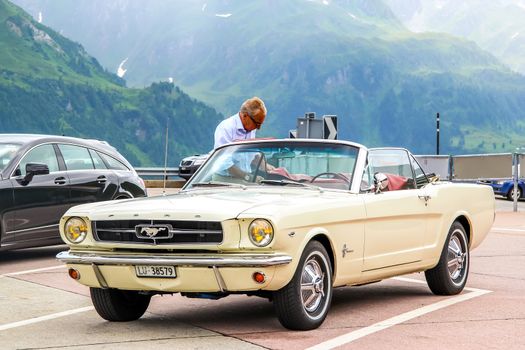 GOTTHARD PASS, SWITZERLAND - AUGUST 5, 2014: Motor car Ford Mustang at the high Alpine mountain road.