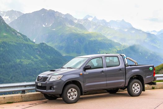 GOTTHARD PASS, SWITZERLAND - AUGUST 5, 2014: Motor car Toyota Hilux at the high Alpine mountain road.