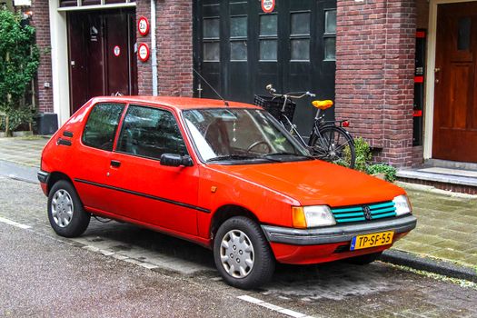 AMSTERDAM, NETHERLANDS - AUGUST 10, 2014: Motor car Peugeot 205 at the city street.