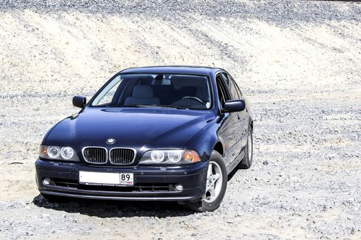 NOVYY URENGOY, RUSSIA - JULY 12, 2014: Motor car BMW E39 520i at the sand quarry.