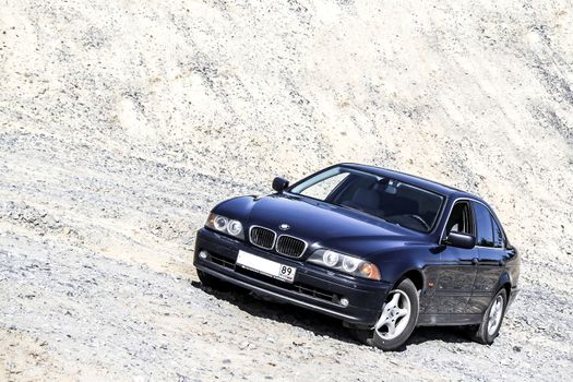 NOVYY URENGOY, RUSSIA - JULY 12, 2014: Motor car BMW E39 520i at the sand quarry.