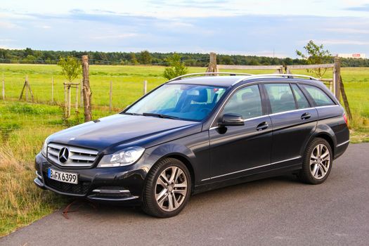 BERLIN, GERMANY - AUGUST 16, 2014: Motor car Mercedes-Benz W204 C180 at the suburban road.