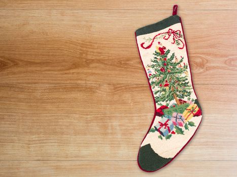 Christmas cross stitch stocking on wood background