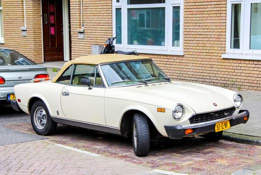 AMSTERDAM, NETHERLANDS - AUGUST 10, 2014: Motor car Fiat 124 Sport Spider at the city street.