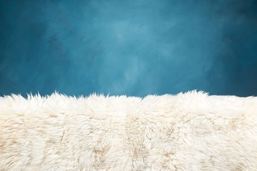 white fur carpet and blue painted wall , use for background