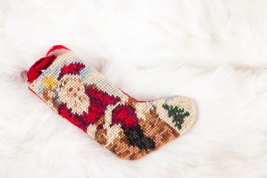 Christmas cross stitch stocking on white fur , use for background