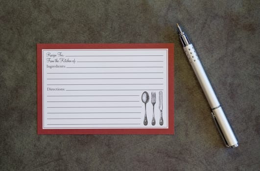Blank recipe card and pen on deep green background