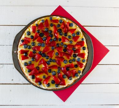 Fresh fruit pizza on red and white background